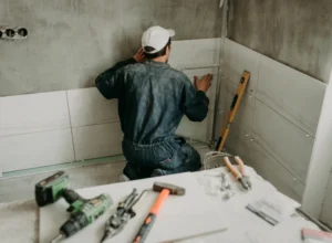 worker repairman puts large ceramic tiles